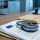 eu-gegevensbescherming-beveiliging-documentenjpg - Hoek en Blok.IT Stalen hangslot op gestapelde EU-documenten en bedrijfsmappen, met digitaal circuitpatroon weerspiegeld op gepolijst oppervlak