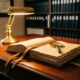 Messing vergrootglas op leren gebonden compliance-documenten op mahonie bureau, verlicht door vintage bureaulamp