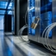 Koperen hangslot op serverrack met blauwe indicatielampjes en stalen kabels in modern datacenter